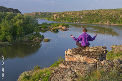 Man sits on a rock above the river