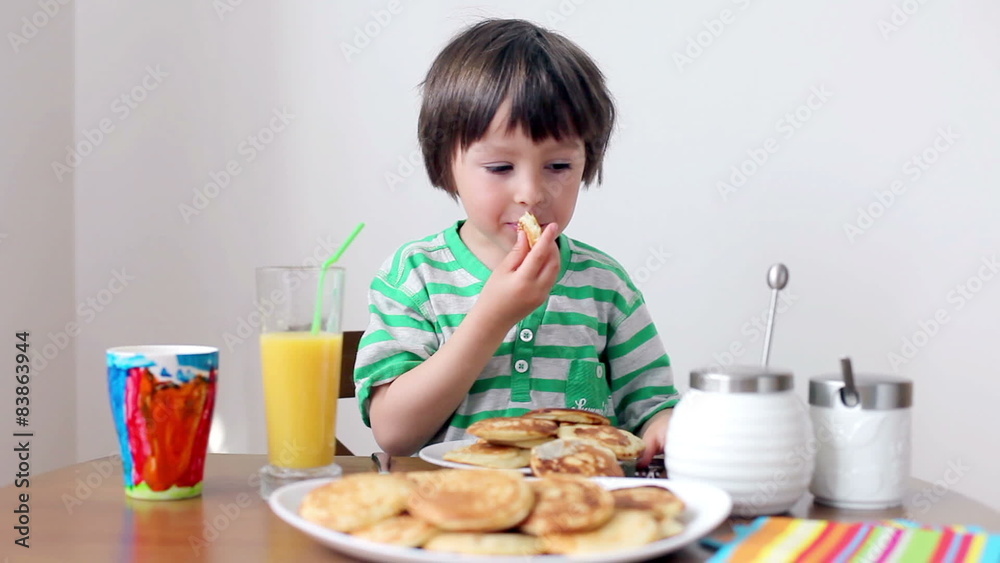 Sweet little caucasian boy, eating pancakes Sweet little caucasian boy, eating pancakes