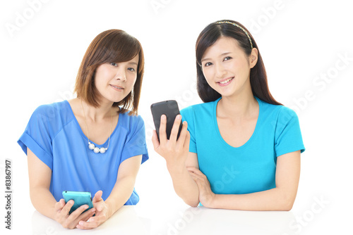スマートフォンを持つ二人の女性