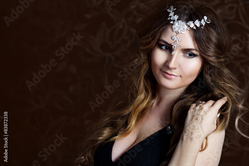 beautiful girl with long brown curled hair, dark background