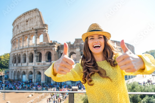 Canvas Print Smiling woman giving two thumbs up at Colosseum in Rome