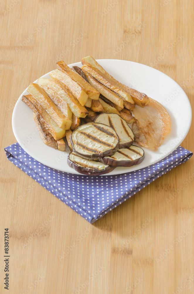 Fries potatoes with grilled eggplant on wooden background Fries potatoes with grilled eggplant on wooden background
