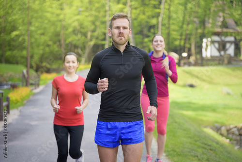 Smiling friends running outdoors.