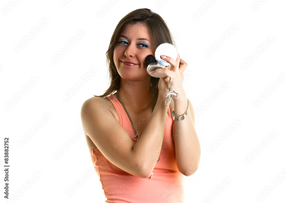 Beautiful young woman with a pink top, putting on make-up. Beautiful young woman with a pink top, putting on make-up.
