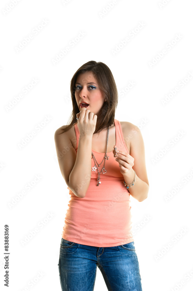 Beautiful young woman with a pink top, putting on make-up. Beautiful young woman with a pink top, putting on make-up.