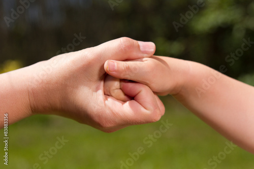 Zwei verschlungene Hände, Erwachsene und Kind Hand © SENTELLO