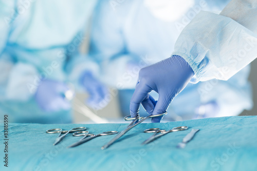 Fototapeta Close-up of scrub nurse taking medical instruments