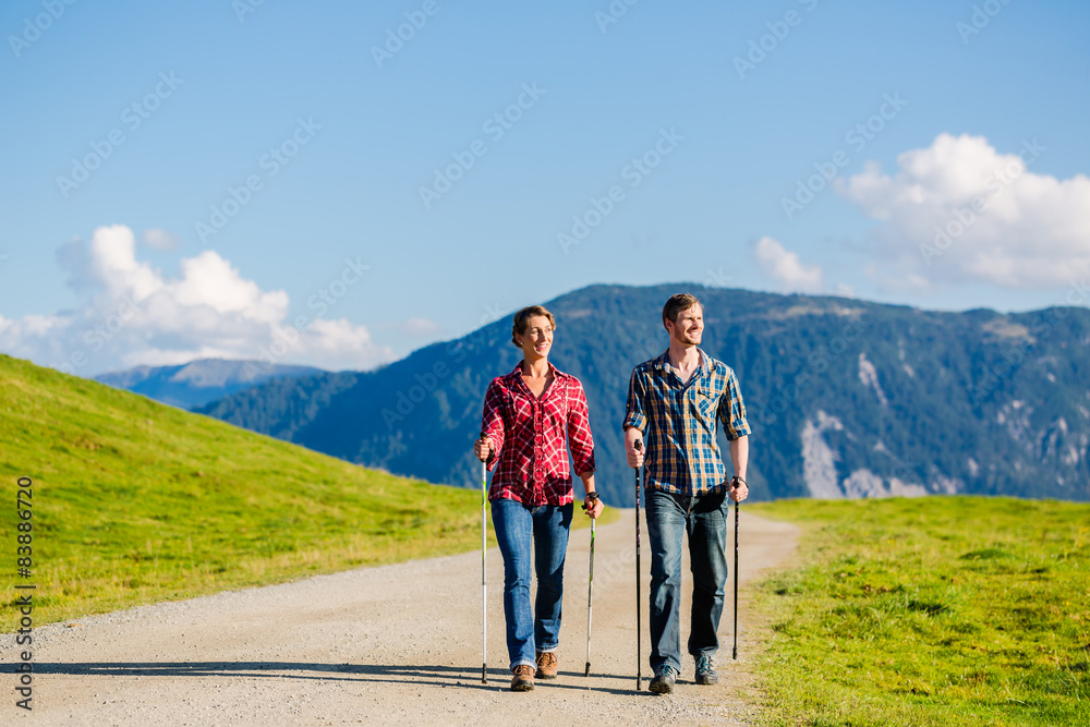 Paar beim Nordic Walking in den Bergen