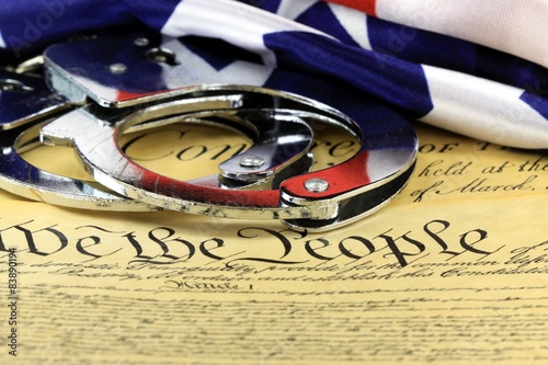 Handcuffs and American flag on US Constitution-Fourth Amendment photo