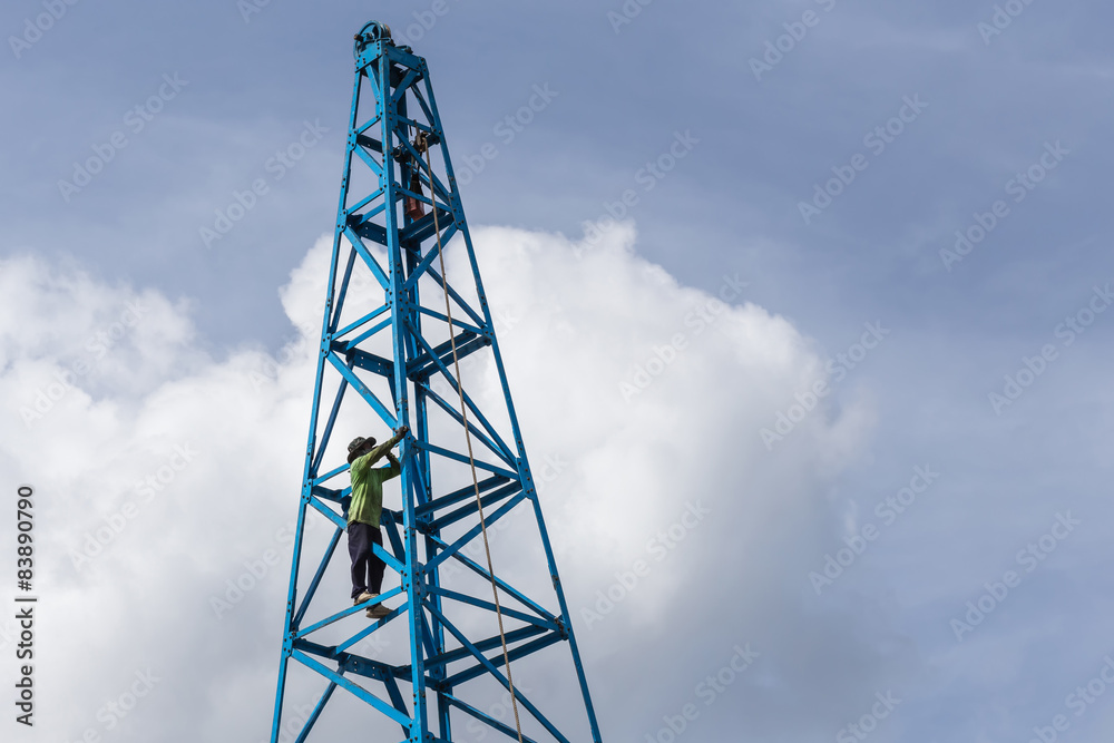 Thai worker working on the blue construction crane