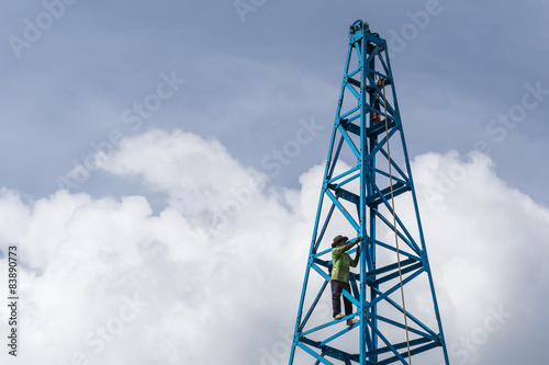 Thai worker working on the blue construction crane
