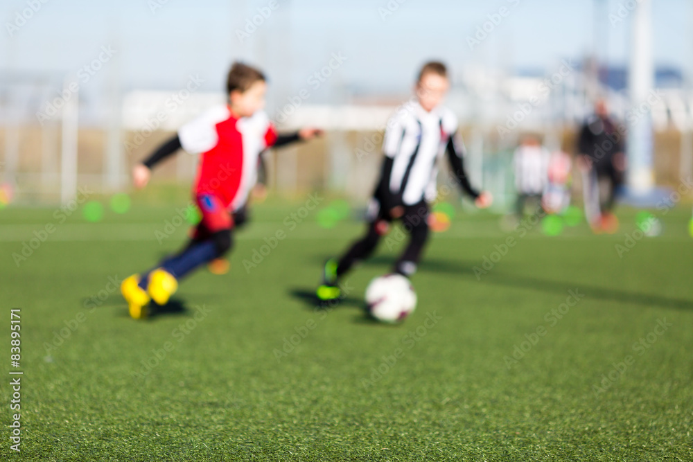 Two blurred kids playing soccer