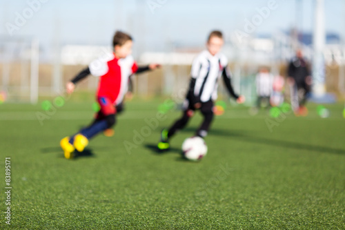 Two blurred kids playing soccer