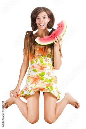 Girl jumping with a slice of watermelon
