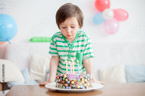 Beautiful adorable four year old boy in green shirt  celebrating
