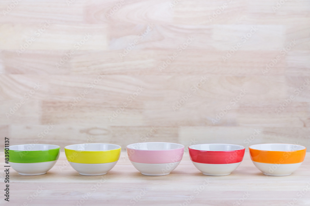 Colorful Ceramic Bowls Stacked On Each Other on Wood Background Colorful Ceramic Bowls Stacked On Each Other on Wood Background