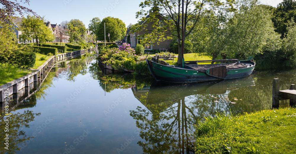 Fototapeta premium Old barge in the canal of a village