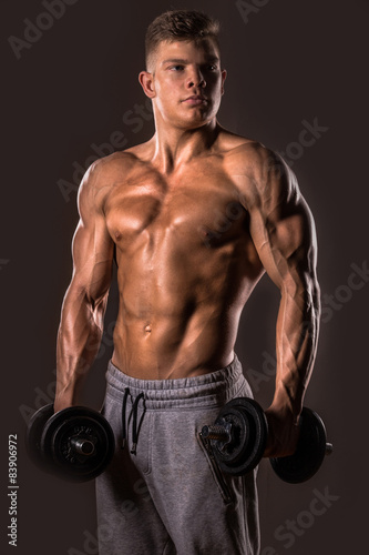 muscular bodybuilder man posing with dumbbells
