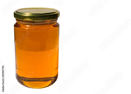 Glass jar of honey on white