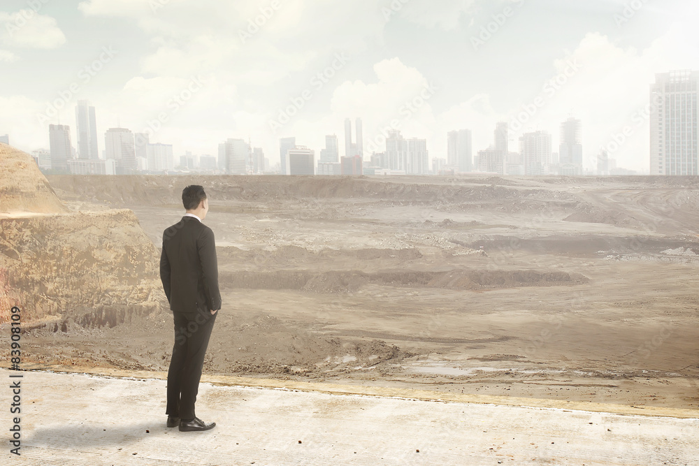 Asian business man looking at the destroyed city Asian business man looking at the destroyed city