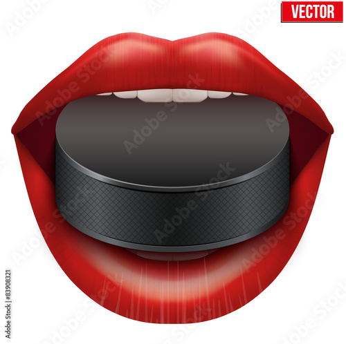 Womans open mouth with ice hockey puck in lips.