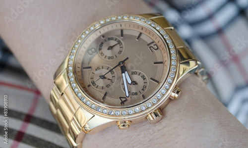 Women's gold watch on the hand