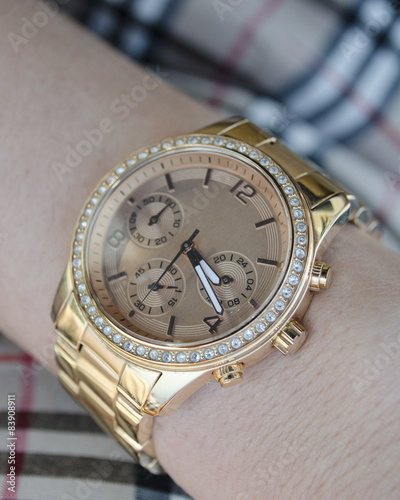 Women's gold watch on the hand