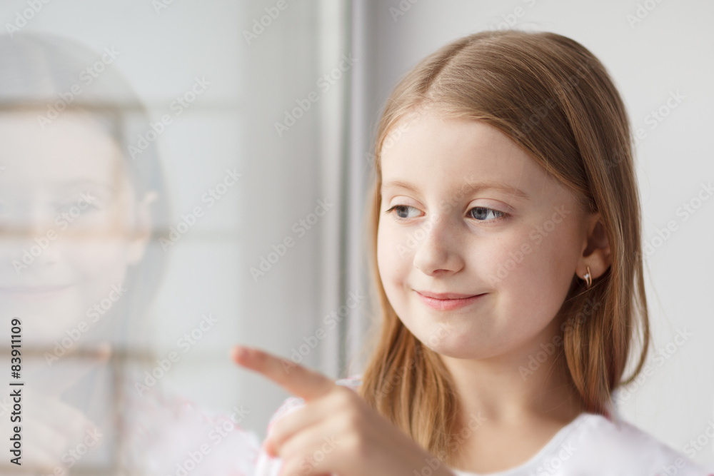 Little girl looking out and points with finger the window Little girl looking out and points with finger the window