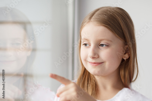 Little girl looking out and points with finger the window Free Download Little girl looking out and points with finger the window - GFXLoad