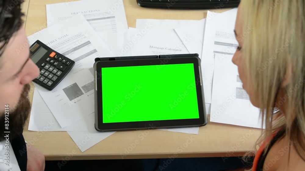 man and woman work on the tablet in the office (papers and calculator) - green screen - with heads