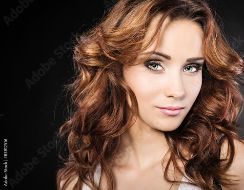 Brunette with beautiful makeup on a dark background 