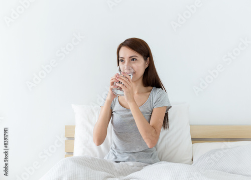 Woman drinking water on the bed