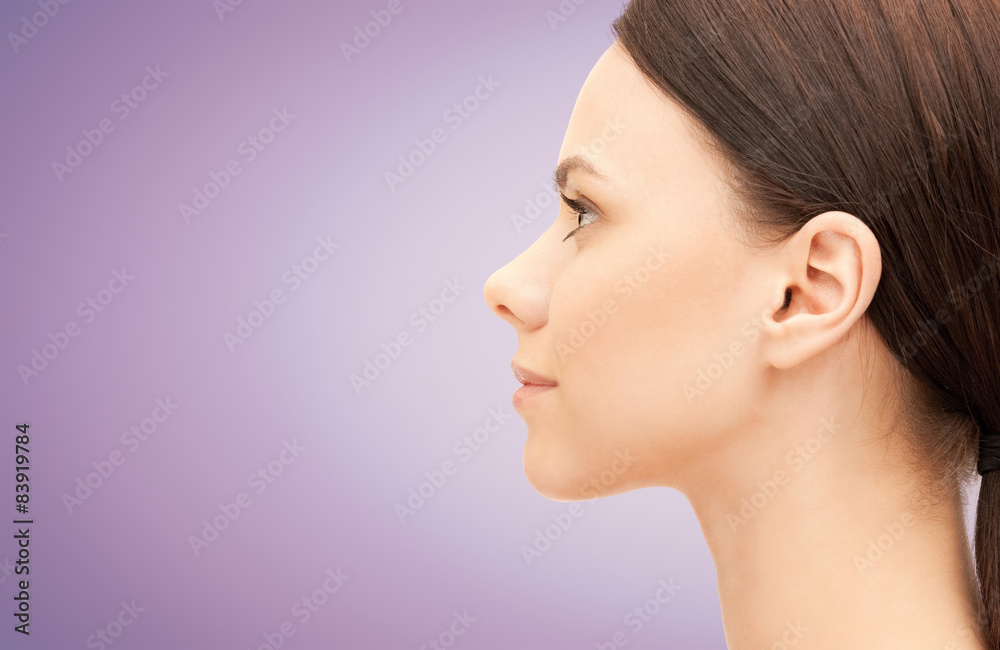 beautiful young woman face over violet background beautiful young woman face over violet background