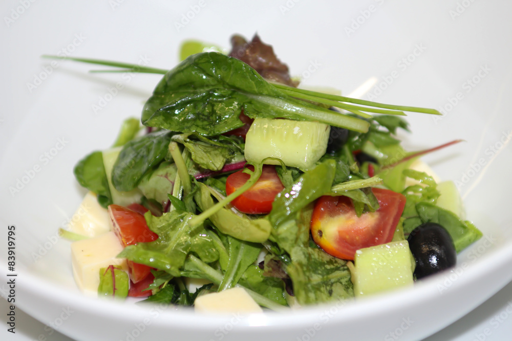 Delicious salad served in a white plate.