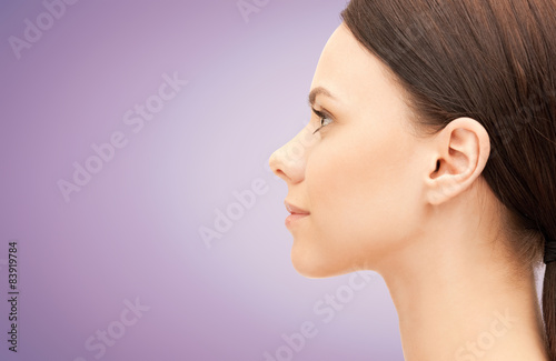 beautiful young woman face over violet background
