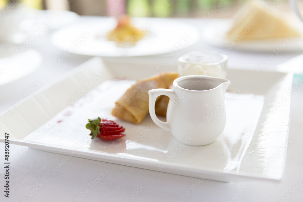 close up of pancakes and honey or jam on plate