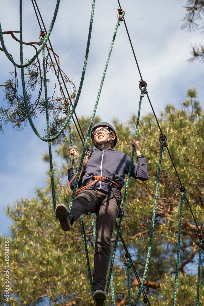 boy climbing in adventure park, rope park  
