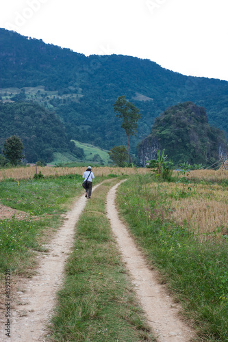 Woman walking on the route towards the mountain.