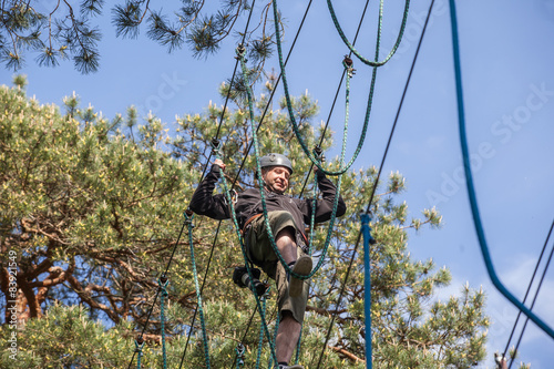 young man climbing in adventure park, rope park 