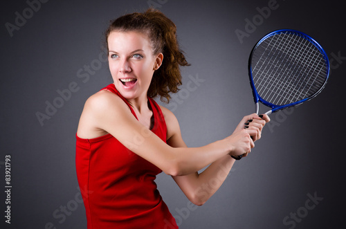 Woman tennis player against dark background