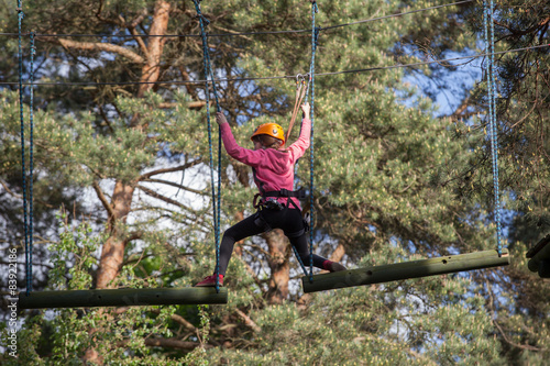 Girl climbing in adventure park , rope park 