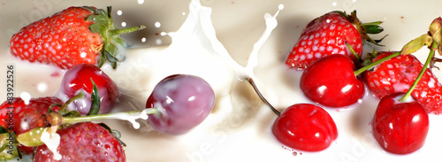 Fototapeta Naklejka Na Ścianę i Meble -  Strawberries and Cherries dropping into milk