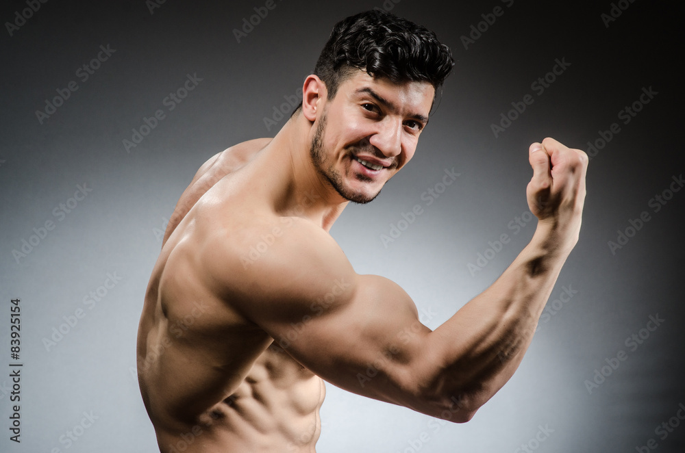 Muscular man posing in dark studio Muscular man posing in dark studio