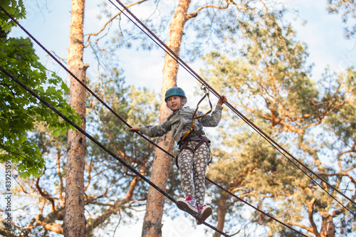  Girl climbing in adventure park , rope park 