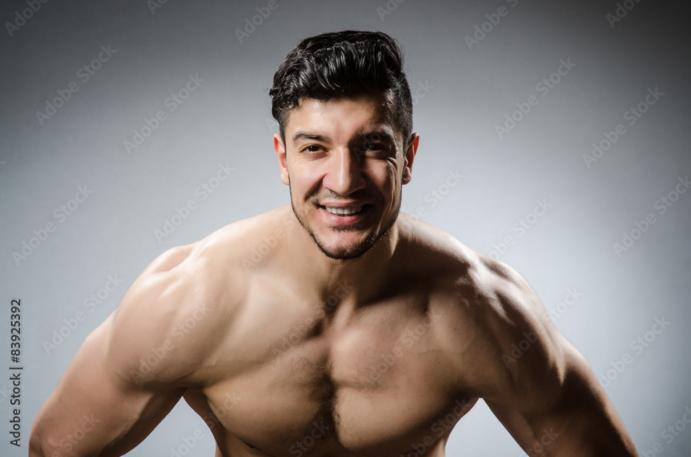 Muscular man posing in dark studio Muscular man posing in dark studio