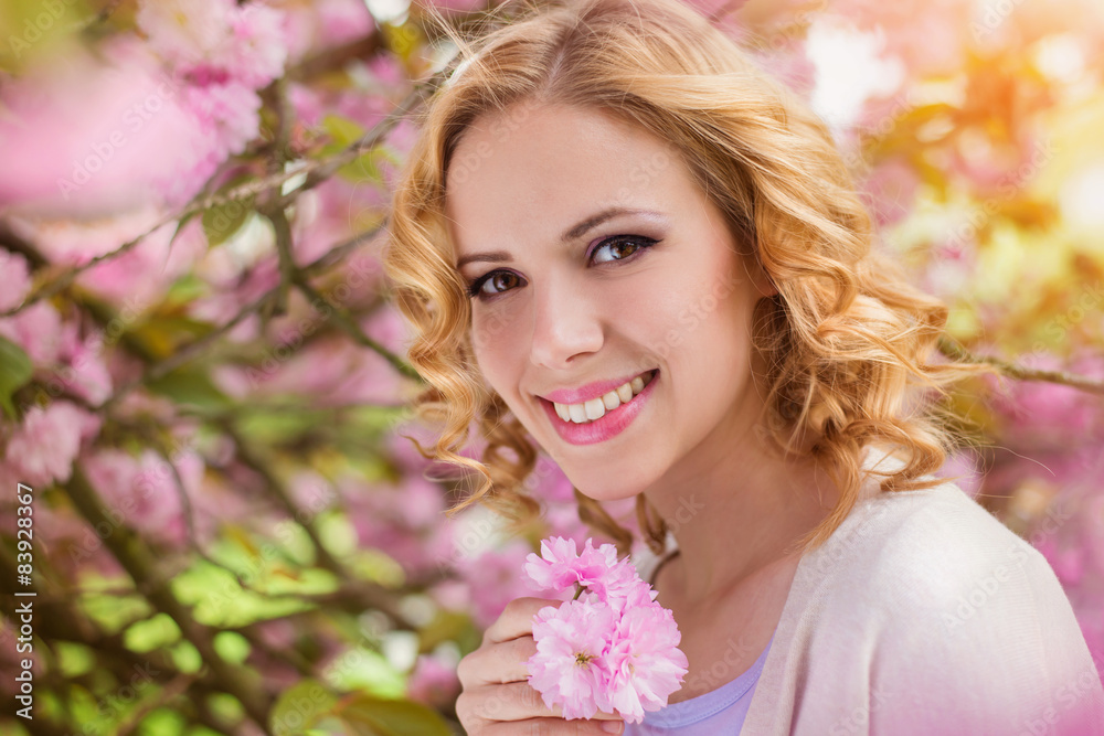 Young beautiful woman outside in front of a blooming tree Young beautiful woman outside in front of a blooming tree