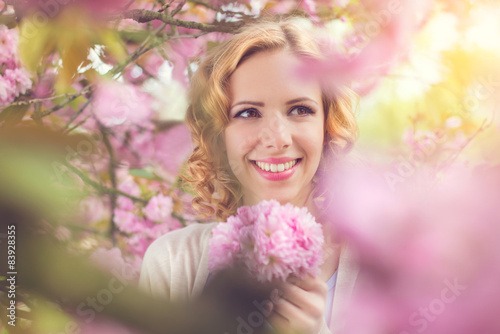 Young beautiful woman outside in front of a blooming tree