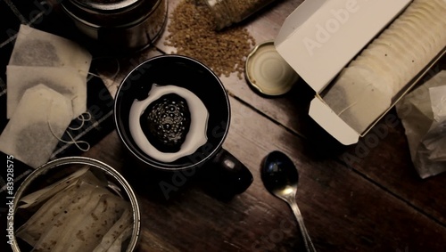 camera defocus and shift focus over to black coffee cup.