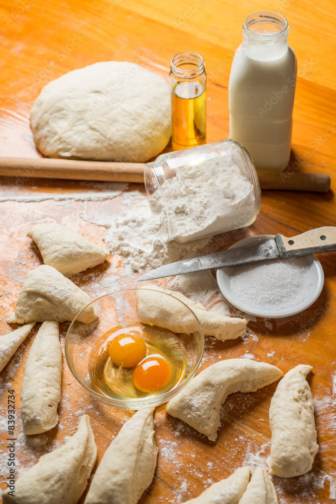 Fototapeta premium dough and flour with an egg, oil and a bottle of milk