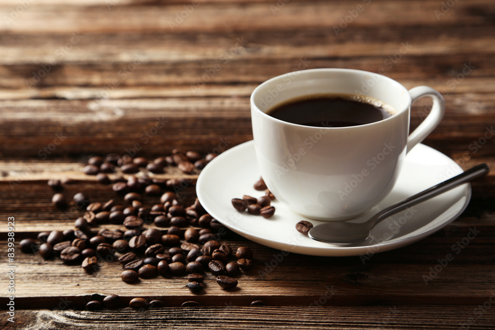 Cup of coffee with coffee beans on brown wooden background Cup of coffee with coffee beans on brown wooden background